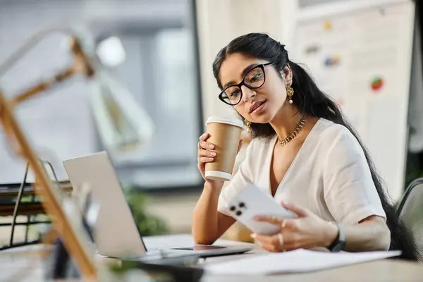 Young indian woman engaged in work at desk with laptop and coffee. — Stock Photo