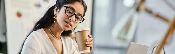 A fashionable indian woman with glasses enjoying a cup of coffee. — Stock Photo