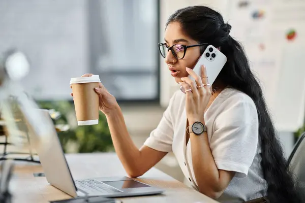 Junge indische Frau chattet am Telefon mit Kaffee in der Hand. — Stockfoto