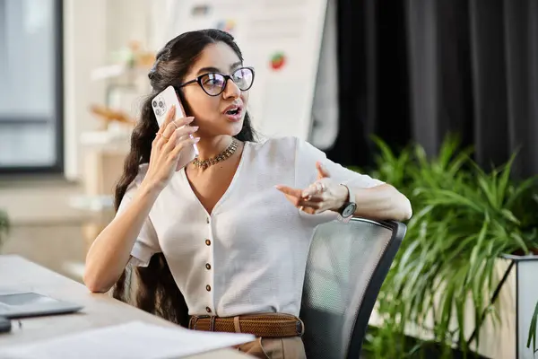 Young indian woman talking on phone at desk. — Stock Photo