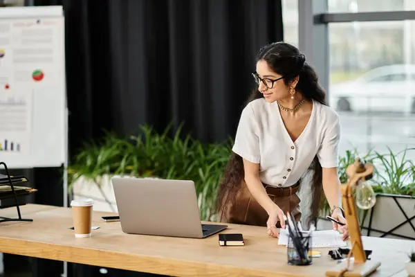 Mulher indiana jovem energeticamente trabalha na mesa com laptop. — Fotografia de Stock