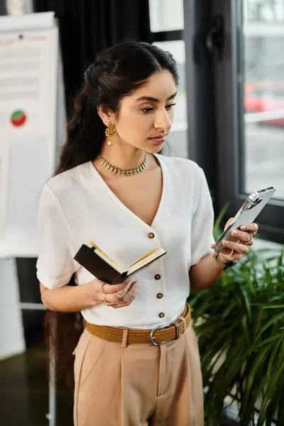 Businessindian woman concentrates on smartphone in office setting. — Stock Photo