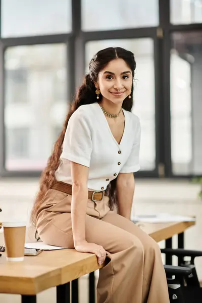 A indian woman relaxes at a desk with a cup of coffee. — Stock Photo