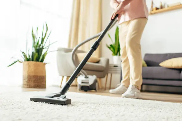 Man in action, using vacuum to clean carpet. — Stock Photo