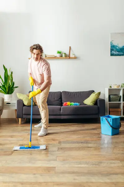 Bello uomo in accogliente casa pulizia pavimento con mop. — Foto stock