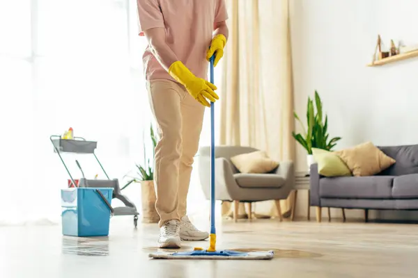 Man in pink sweater mops floor — Stock Photo