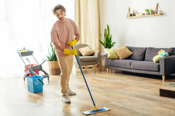 Un homme habillé à la maison nettoie gracieusement le sol. — Photo de stock