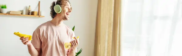 A handsome man in cozy homewear holds spray for cleaning. — Stock Photo