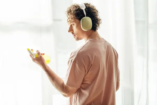 A man in headphones with spray. — Stock Photo