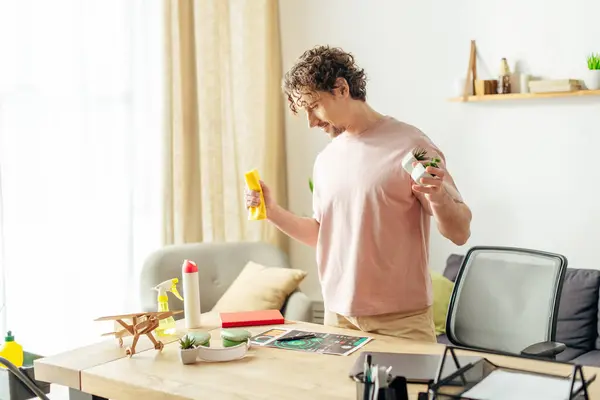 Bonito homem em casa aconchegante segurando um spray em uma sala de estar. — Fotografia de Stock