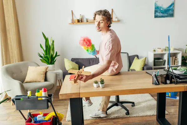 A elegant man sitting at a table holding a duster. — Stock Photo