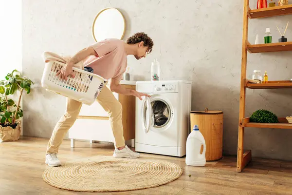 Mann hält Wäschekorb an Waschmaschine — Stockfoto