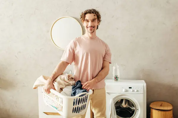 A gentleman in cozy homewear stands next to a washing machine. — Stock Photo