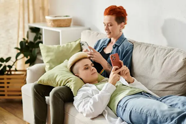 Frauen mit kurzen Haaren sitzen auf einer Couch, in ihre Handys vertieft. — Stockfoto