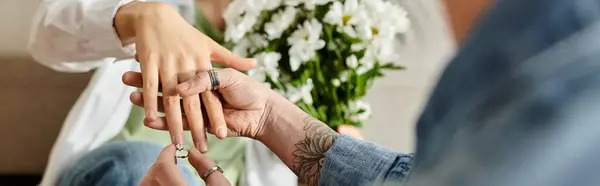 Woman gently places a ring on a hand of partner in a heartwarming gesture of love and commitment. — Stock Photo