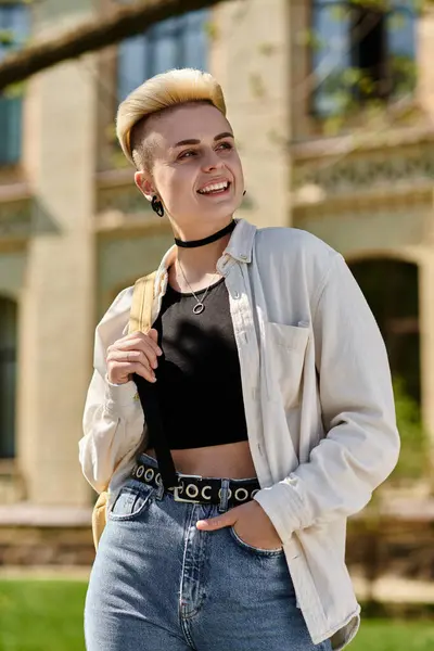 Giovane donna con fiducia puntoni in jeans e una t-shirt, in mostra la testa rasata all'aperto in un campus universitario. — Foto stock