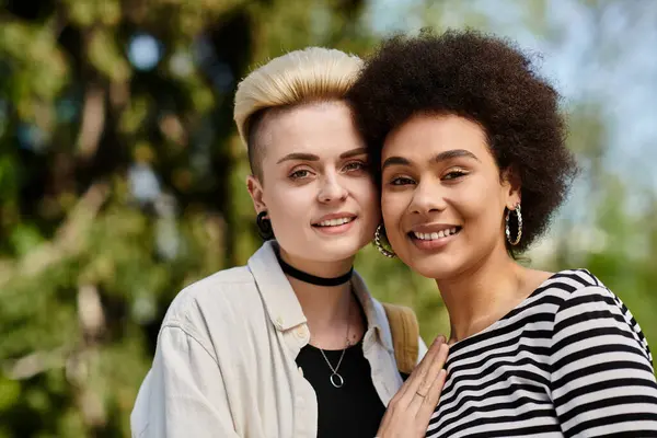 Deux jeunes femmes, posent dans un parc luxuriant, exsudant amitié et joie. — Photo de stock