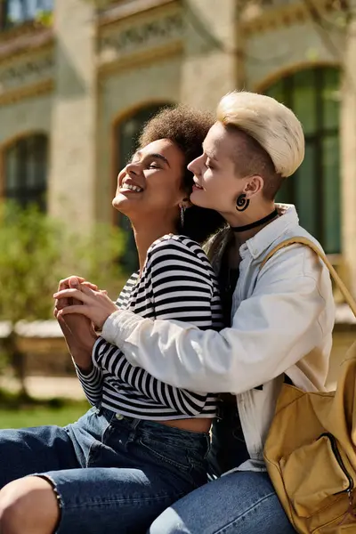 Due giovani ragazze multiculturali siedono su una panchina, condividendo un caldo abbraccio mentre esprimono amore e amore l'una verso l'altra.. — Foto stock