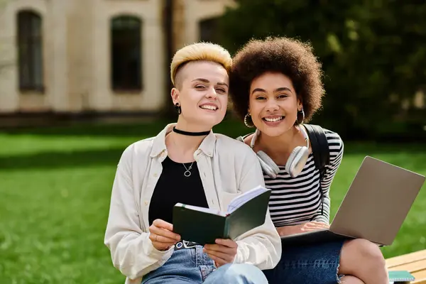 Zwei junge Frauen, die auf einer Bank in ein Buch vertieft sind, während sie gemeinsam lesen und sich vertiefen. — Stockfoto