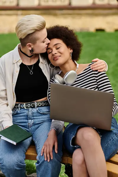 Two women engaged in teamwork on a bench with a laptop, brainstorming ideas and having a discussion. — Stock Photo