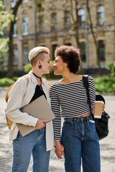 Дві молоді жінки різного походження стоять в місті, одягненому в джинси і футболки, виключаючи прохолодну і впевнену ауру. — стокове фото
