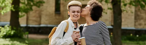 Ein Moment der Liebe zwischen zwei jungen Frauen, die in einem Park spazieren gehen und einen innigen Kuss austauschen. — Stockfoto