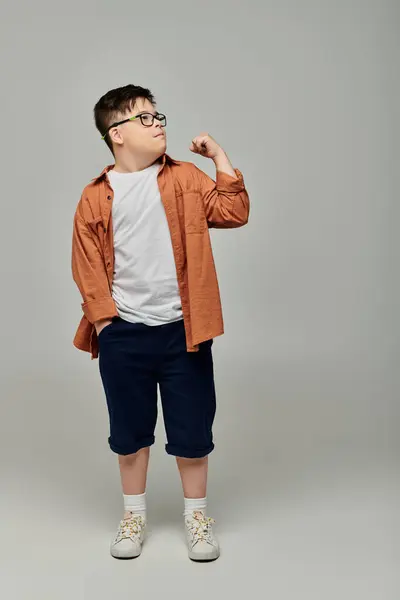 Adorable little boy with Down syndrome wearing glasses poses for the camera. — Stock Photo