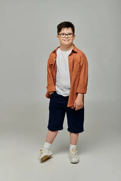 A cute boy with Down syndrome in glasses and shorts posing for a portrait — Stock Photo