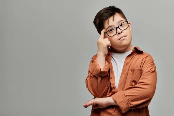 Adorable boy with Down syndrome posing thoughtfully with hand on head. — Stock Photo