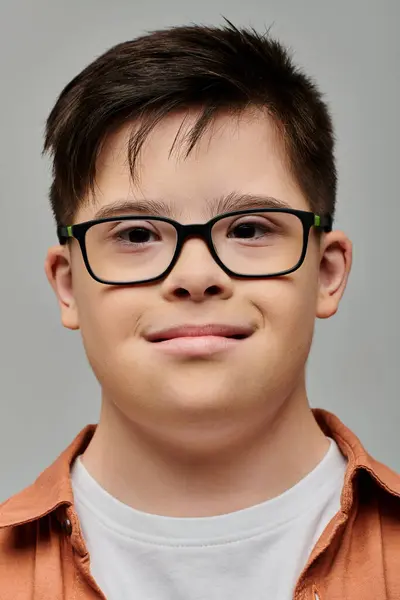 Charming little boy with Down syndrome smiling warmly at the camera — Stock Photo