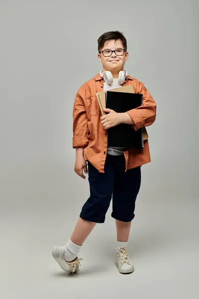 Little boy with Down syndrome with glasses, holding a folder. — Stock Photo