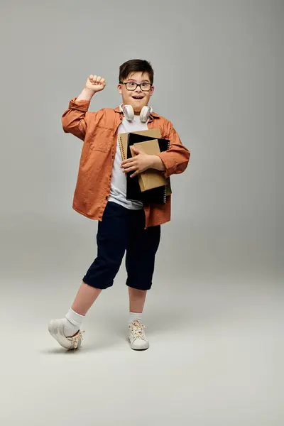 Un petit garçon trisomique tenant un livre et posant. — Photo de stock