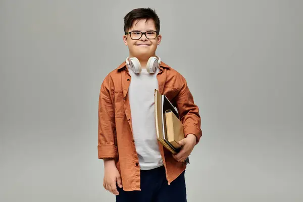 Little boy with Down syndrome holding a books and wearing glasses. — Stock Photo