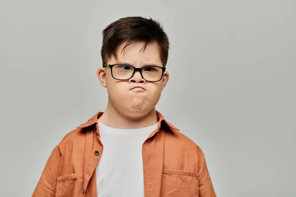 A little boy with Down syndrome with glasses showcasing his playful and mischievous side. — Stock Photo