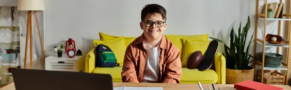 Adorable garçon avec trisomie 21 concentré sur ordinateur portable au bureau. — Photo de stock
