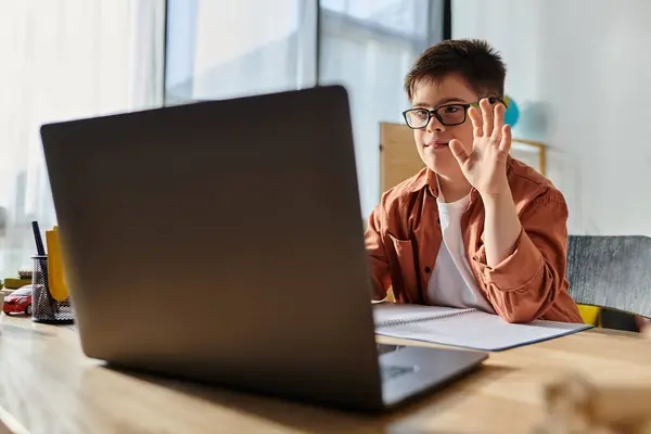 Petit garçon avec trisomie 21 au bureau avec ordinateur portable. — Photo de stock