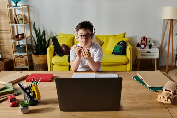 Entzückender Junge mit Down-Syndrom mit Laptop am Schreibtisch. — Stockfoto