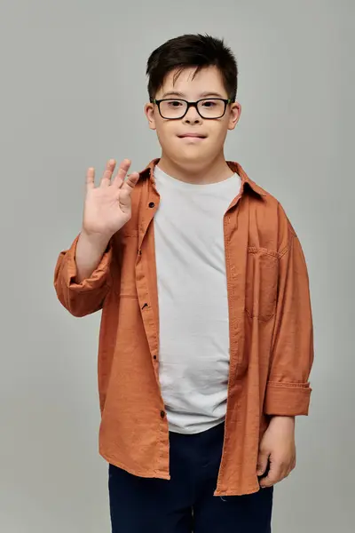 A charming little boy with Down syndrome, wearing glasses, strikes a pose for the camera. — Stock Photo