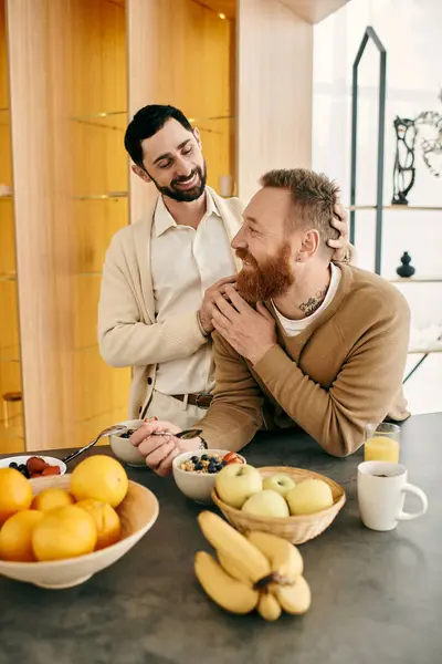 Two gay men, happy and relaxed, laugh together in a modern kitchen. — Stock Photo