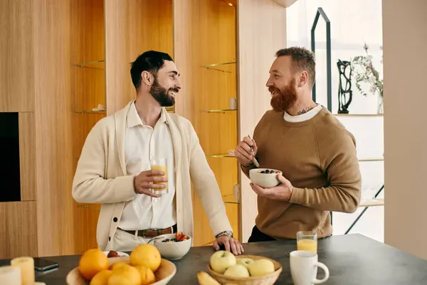 Um casal gay feliz tomando café da manhã em uma cozinha moderna. — Fotografia de Stock