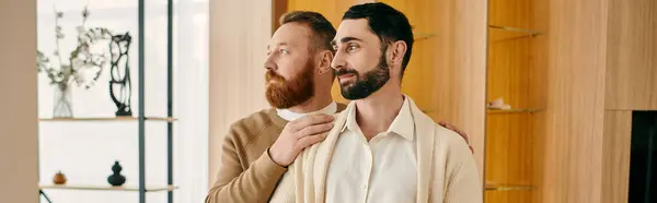 Two happy men stand next to each other in a modern living room, showcasing love and togetherness in their LGBT relationship. — Stock Photo