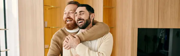Two men, a happy gay couple, embrace warmly in a modern living room adorned with stylish decor. — Stock Photo
