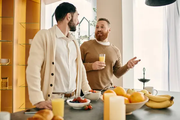 Dos hombres participan en una conversación en una cocina elegante, disfrutando de la compañía de los demás. - foto de stock