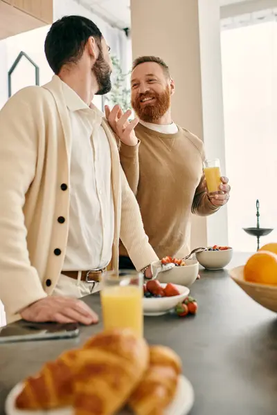 Dois homens gays felizes desfrutar de café da manhã juntos em uma cozinha moderna, compartilhando um momento de amor e companheirismo. — Fotografia de Stock