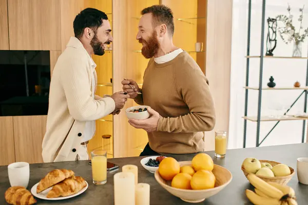A happy gay couple sharing breakfast in a modern kitchen, expressing love and togetherness. — Stock Photo