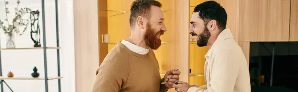Двое мужчин стоят, разделяя момент связи и любви в современной квартире. — стоковое фото
