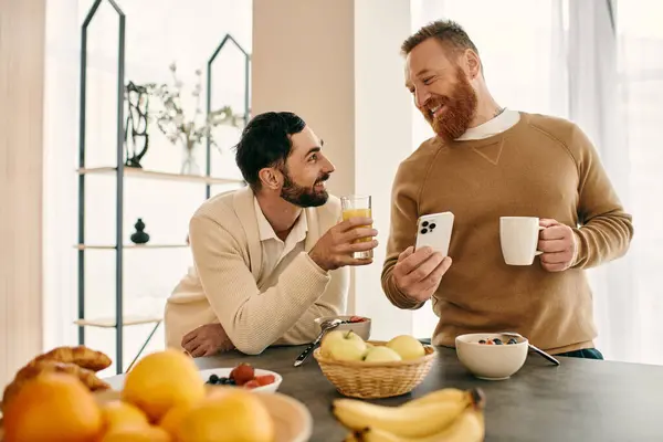 Dos hombres participan en una animada conversación en una mesa en un apartamento moderno. - foto de stock
