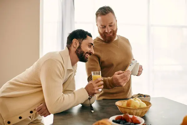 Two men enjoy breakfast together in a modern kitchen, sharing a moment of love and connection. — Stock Photo