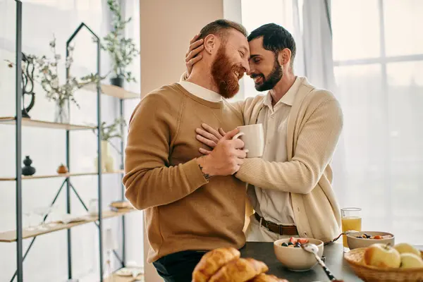 Two men hug warmly in a modern kitchen, their faces reflecting joy and contentment as they share a moment of intimate connection. — Stock Photo
