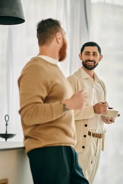 Two men engaged in conversation while standing in a modern kitchen. — Stock Photo